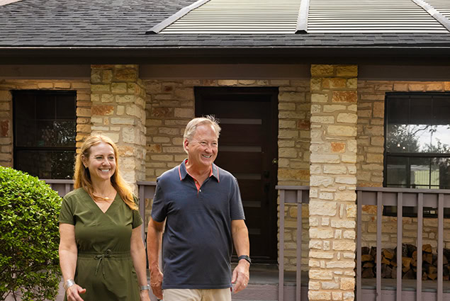 Couple in front of their house with solar roof